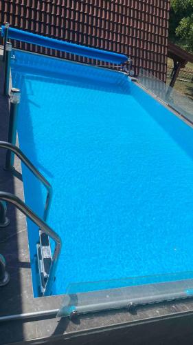 a large blue swimming pool next to a building at Vila Paradiso in Slatina Varoš