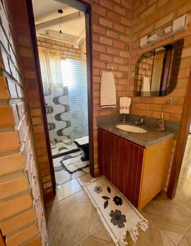 a bathroom with a sink in a log cabin at Estação Serrana in Pedro II