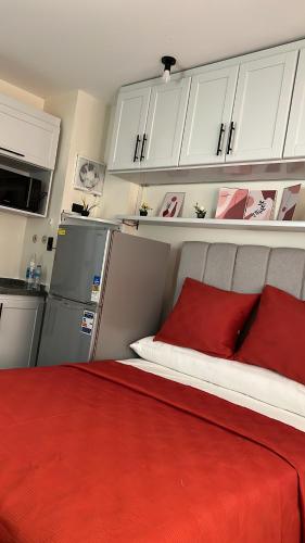 a bedroom with a red bed with white cabinets at Zahra Elegant Studio in Sīdī ‘Abd ar Raḩmān