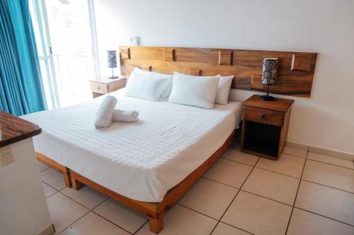 a bedroom with a large bed with a wooden headboard at Hotel La Joya Del Lago in Ajijic