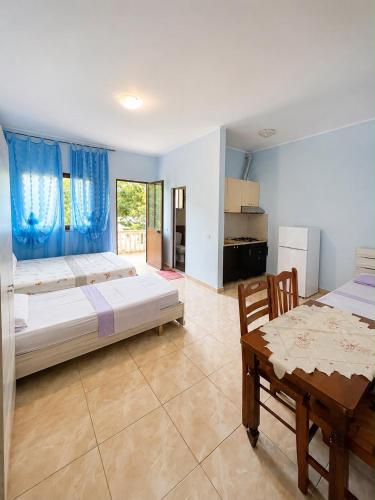 a large bedroom with two beds and a table at Hotel Marino in Baks-Rrjoll
