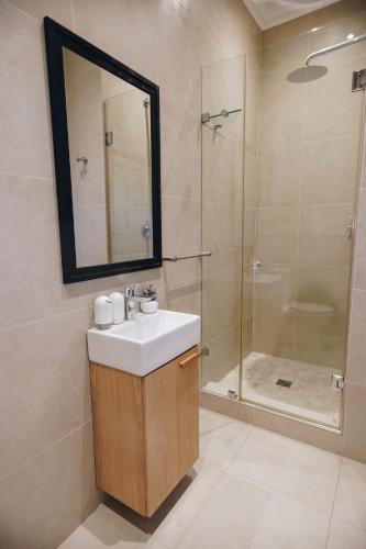 a bathroom with a sink and a shower at Suite 273 - Luxe Solar Suite - Heated Pool in Cape Town