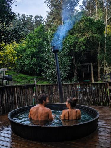 a man and a woman sitting in a hot tub at Lodge Los Bosques in Matanzas