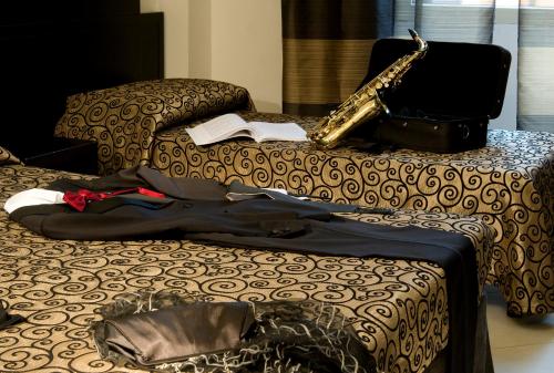 a bed with a book and a saxophone on it at Hotel Sonya in Rome