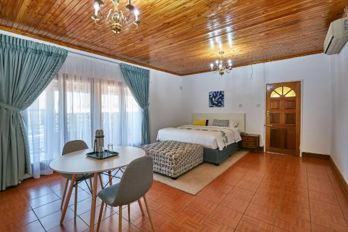 a bedroom with a bed and a table and chairs at 4bnb in Gaborone