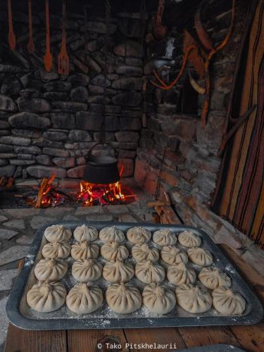 a tray of donuts in front of a brick oven at Gudani Temi in Gudani
