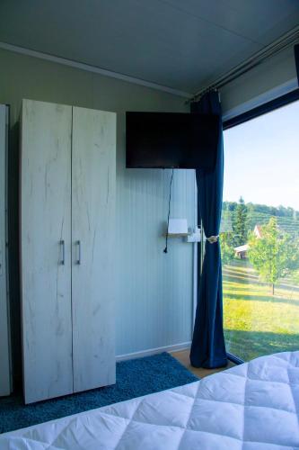 a bedroom with a bed and a large window at Casa Dunja Čačak in Čačak