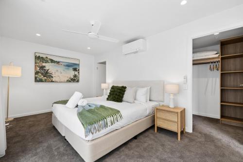 a white bedroom with a white bed and a closet at Sakara at Marochydore in Maroochydore