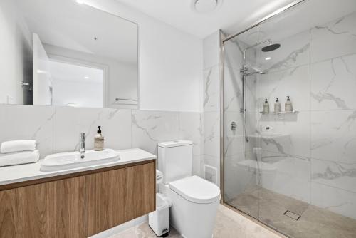 a bathroom with a shower and a toilet and a sink at Sakara at Marochydore in Maroochydore