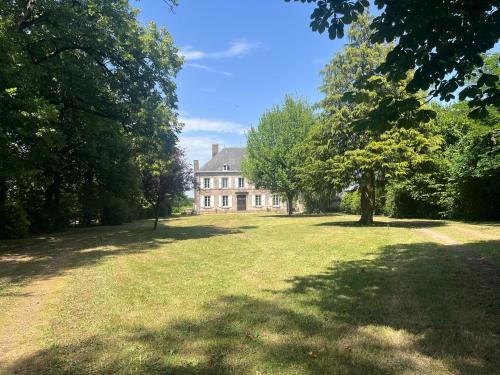 a large house in the middle of a field with trees at Château Talence 1870 in LʼAbsie