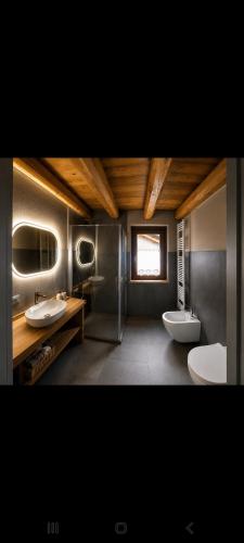 a bathroom with two sinks and two toilets at Enfin Clavon - appartamento in baita in Verrayes