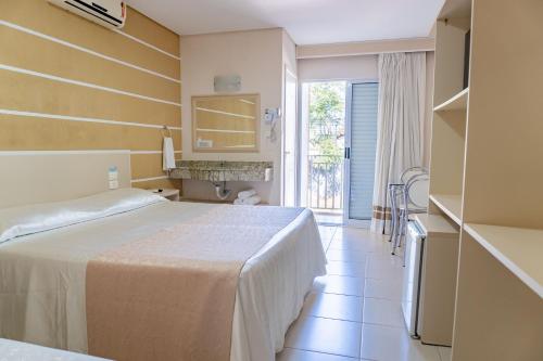 a hotel room with two beds and a balcony at Pousada Cataratas in Foz do Iguaçu