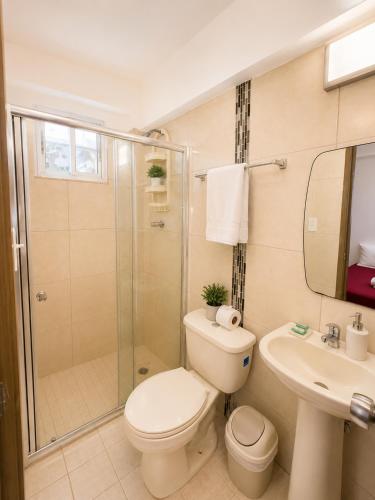 a bathroom with a toilet and a shower and a sink at Pacific Coast Hotel in Playa Bonita Village