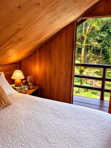 a bedroom with a bed and a large window at Cabana Liberdade in Rio dos Cedros