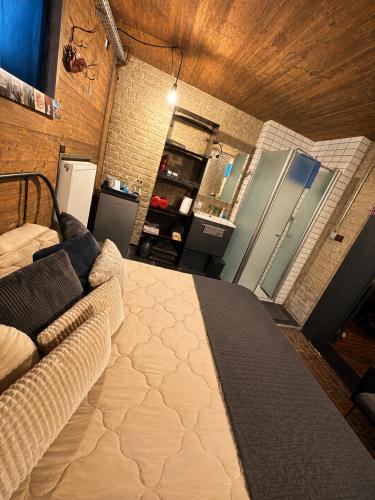 a bedroom with a large bed and a refrigerator at Les chambres atypiques de Nico Bush - Parking sécurisé vélos in Tournai