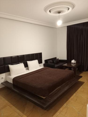 a bedroom with a large bed with a black headboard at Hotel Bouery in An Nā‘ūrah