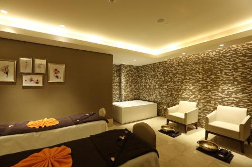 a bedroom with two beds and a stone wall at Feathers- A Radha Hotel, Chennai in Chennai