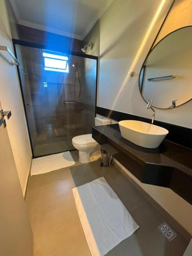 a bathroom with a sink and a toilet and a mirror at Pousada Vila Palmital in Paraty