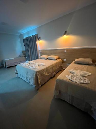 a hotel room with two beds with towels on them at Pousada Vila Palmital in Paraty