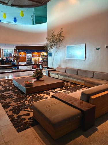 a living room with a couch and tables in a lobby at Flat com vista para o mar - apto 1605 in Natal