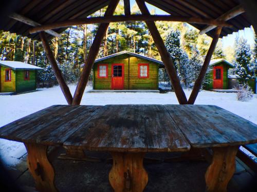 a wooden table in a gazebo with houses at Kuivastujaani in Kuivastu