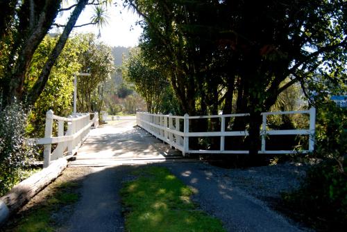 a white bridge on a road with a fence at Apostles View Motel in Greymouth