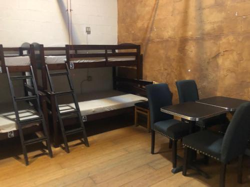 a room with two bunk beds and a table and chairs at Cottage bed 4 at FacesOasis in Oakland