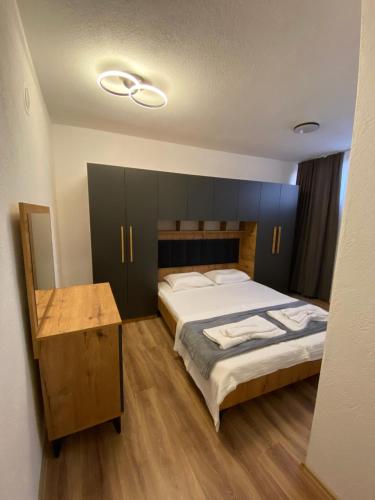 a bedroom with a large bed and a wooden table at Gashi Home in Prizren