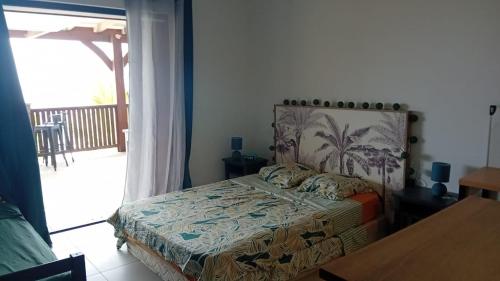 a bedroom with a bed and a balcony at Villa Hill-Sea in Saint Martin