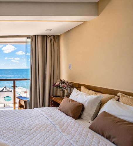 a bedroom with a bed with a view of the ocean at Pousada Manhã Dourada in Morro de São Paulo