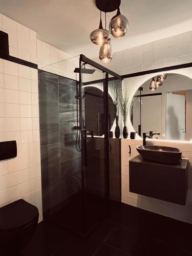 a bathroom with a sink and a toilet and a mirror at Mountain Loft Nassfeld in Tröpolach