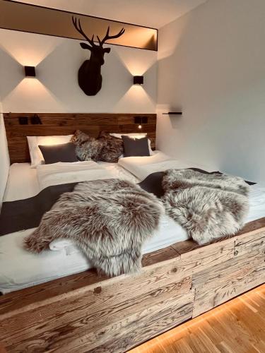 a bedroom with two beds with faux fur pillows at Mountain Loft Nassfeld in Tröpolach