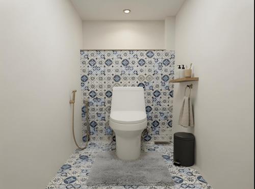 a bathroom with a toilet with blue and white tiles at Zen Cove Villa - 5-Min Walk to Zen Beach, Srithanu in Haad Chao Phao