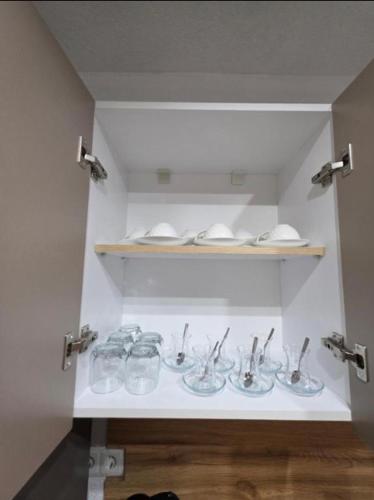 a shelf with several dishes and spoons in a room at Gashi Home in Prizren