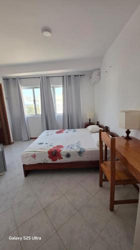 a bedroom with a bed with flowers on it at Residencial Raiar in Mindelo