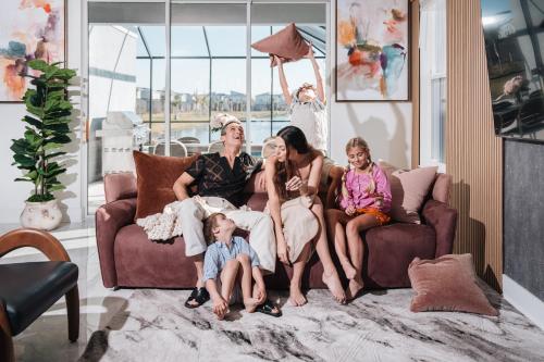 a family sitting on a couch in a living room at Villatel Orlando Resort in Orlando