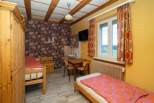 a bedroom with two beds and a table and a window at Monteurzimmer Linde in Limbach