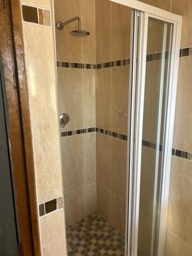 a shower with a glass door in a bathroom at Alwaba guest house in Mthatha