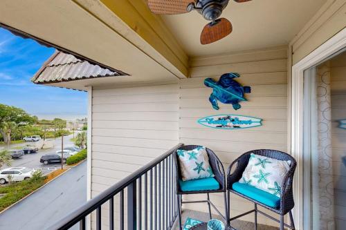 two chairs on a porch with a surfboard on the wall at HH Beach & Tennis 319B in Hilton Head Island