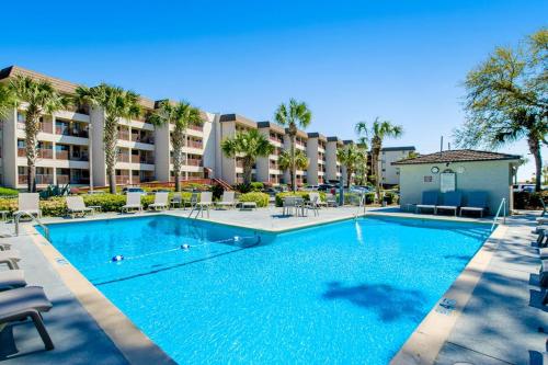 a swimming pool with chairs and a hotel at HH Beach & Tennis 319B in Hilton Head Island
