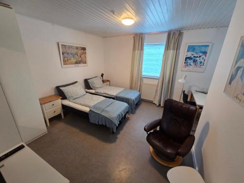 a bedroom with a bed and a chair in a room at Hine Bakke Bed And Breakfast in Rudkøbing