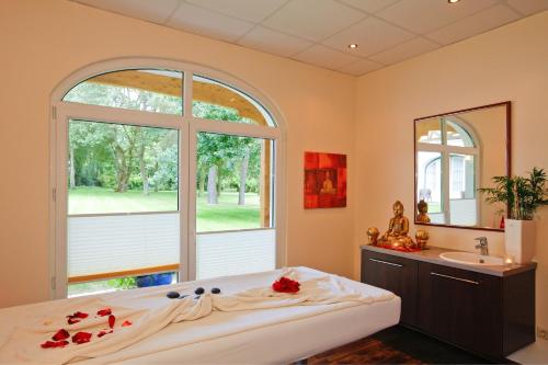 a bedroom with a large window and a bed and a sink at Boutique Hotel Azul in Möhnesee