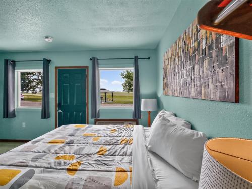 a bedroom with a bed and a blue wall at Clara City Inn in Clara City