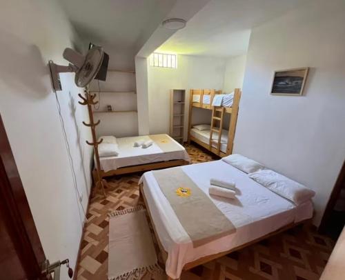 a room with two beds and two bunk beds at Mihahi Beach Mancora in Máncora