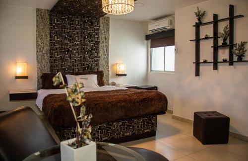 a bedroom with a bed and a table in a room at Hotel Velario in Tijuana