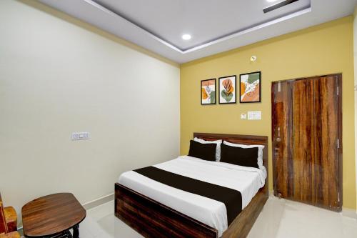 a bedroom with a bed and a wooden cabinet at Super HOTEL O GOLDEN CITY INN in Maula Ali
