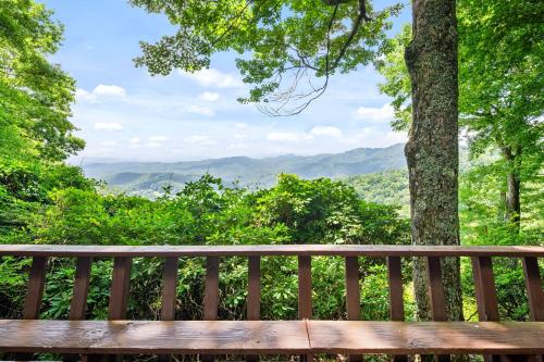 a wooden bench with a view of the mountains at Blue View Chalet in Blowing Rock