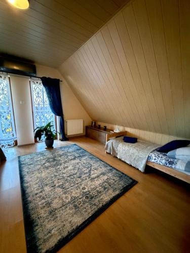 an attic bedroom with two beds and a rug at Piękna Góra in Giżycko