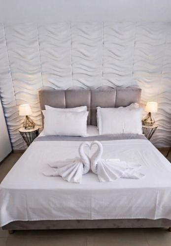 a white bed with a bow on top of it at Boutique lux apartments in Kavála