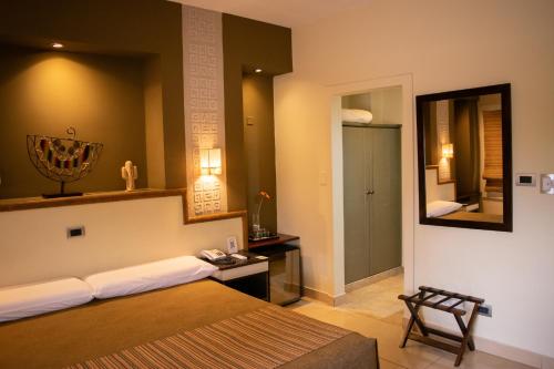 a bedroom with a bed and a mirror and a door at Hotel Inkai in Salta